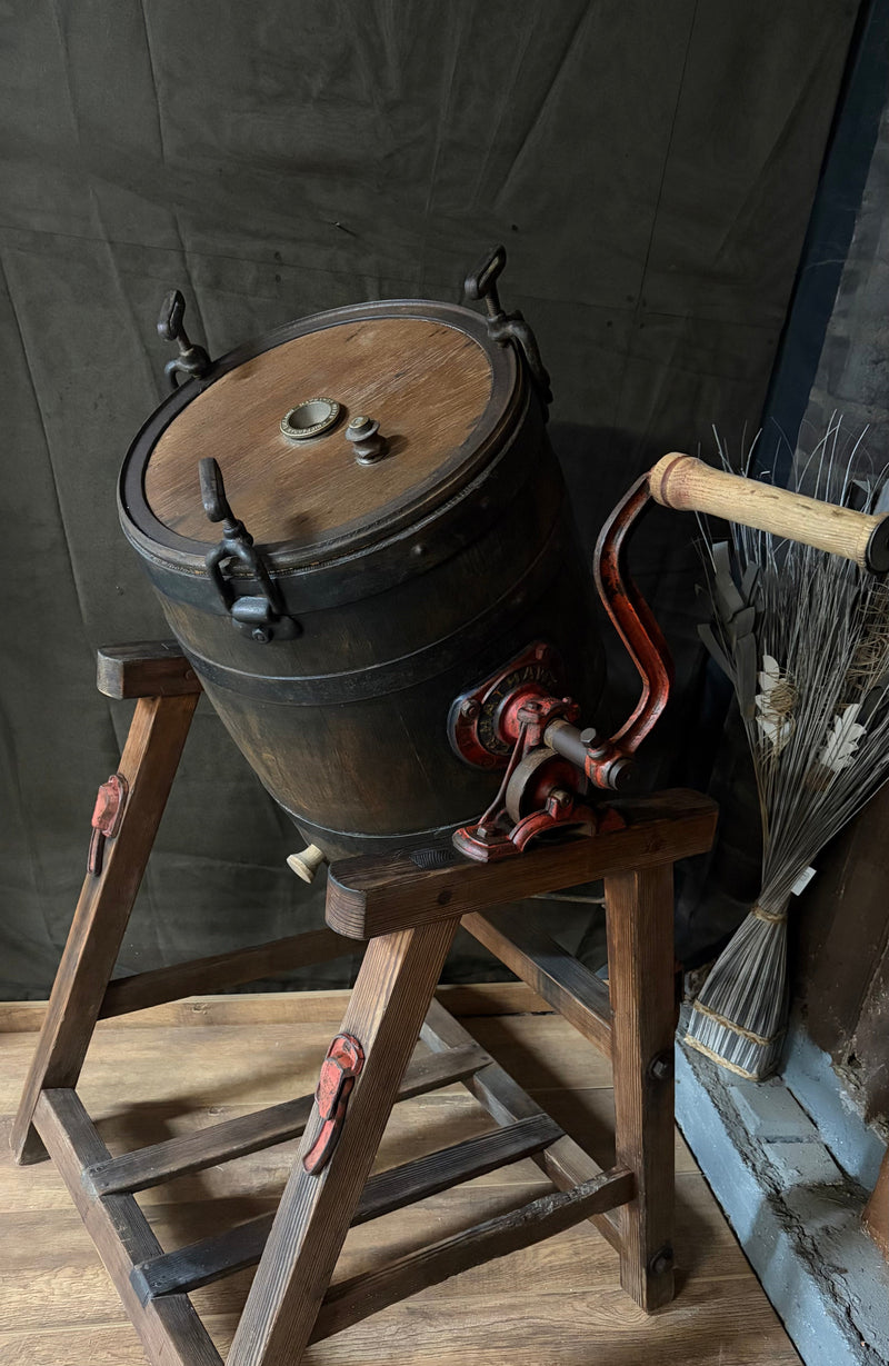 Vintage-style wooden barrel with metal clamps on a wooden stand against a dark background