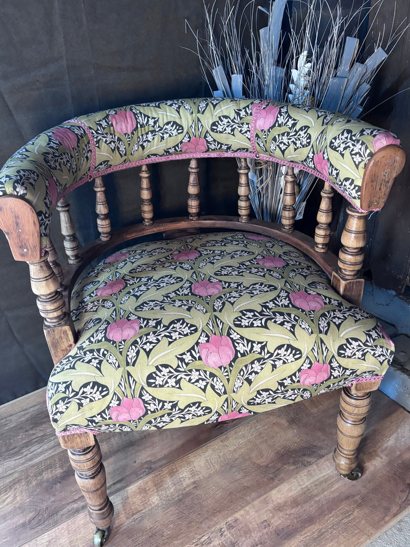Vintage chair with floral patterned fabric on a wooden floor.